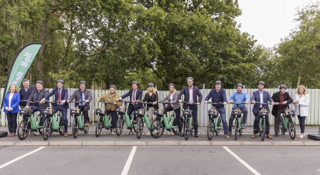 Many people wearing helmets and sitting on Bolt e-bikes.