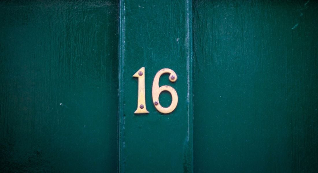 Teal coloured door with number 16 on it in gold lettering.