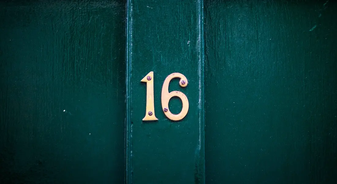 Teal coloured door with number 16 on it in gold lettering.