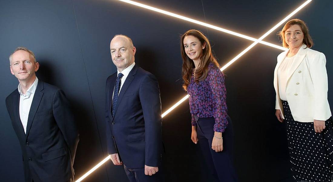 Two men and two women standing as if in a queue at the launch of the new data analytics framework for business.