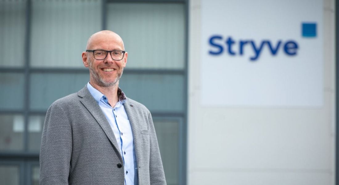 Stryve CEO Andrew Tobin standing outside a building with the Stryve logo on it in blue letters.