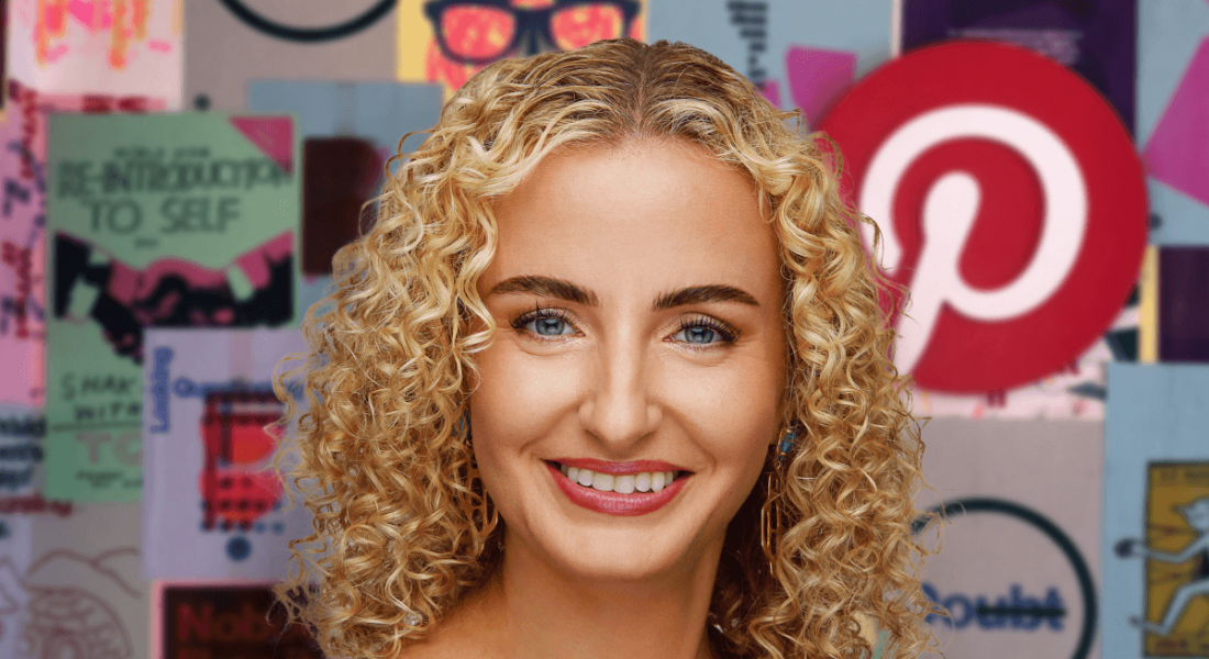 A woman with blonde curly hair smiles at the camera. Behind her is a wall with many images, including the Pinterest logo.