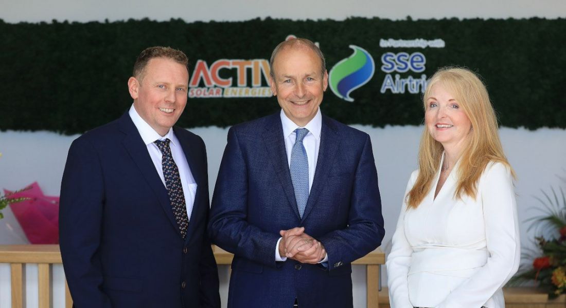 Three people stand in an office that says Activ8 solar and SSE Airtricity on the wall behind them.