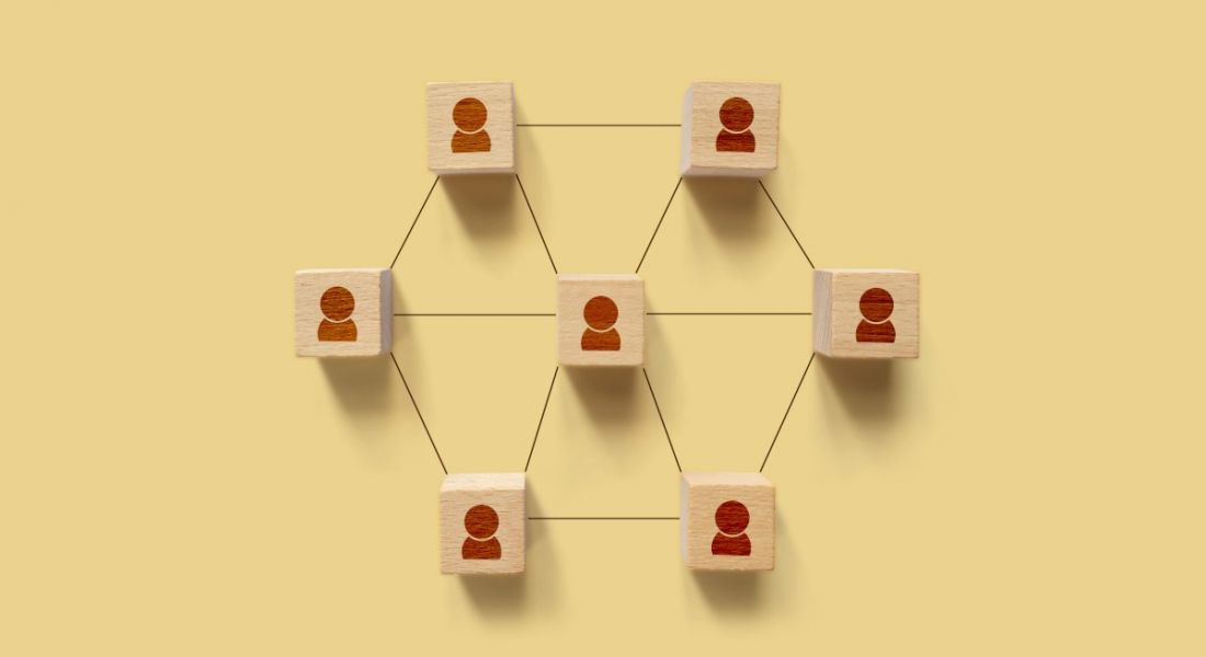 Wooden blocks with a person outline on each one. They are connected by lines like spokes on a wheel, showing employee engagement.