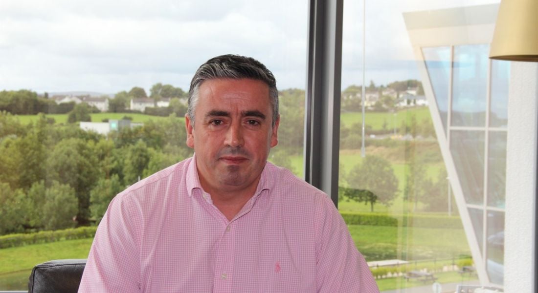 Gerard Grant, director, strategic initiatives at Tata Consultancy Services (TCS) in Ireland sitting in front of a window with a green field outside.