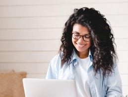 Young woman sitting at a laptop looking at graduate job applications