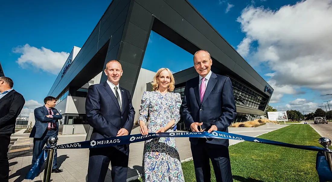 Three people cut the ribbon to open a new manufacturing facility in Shannon.