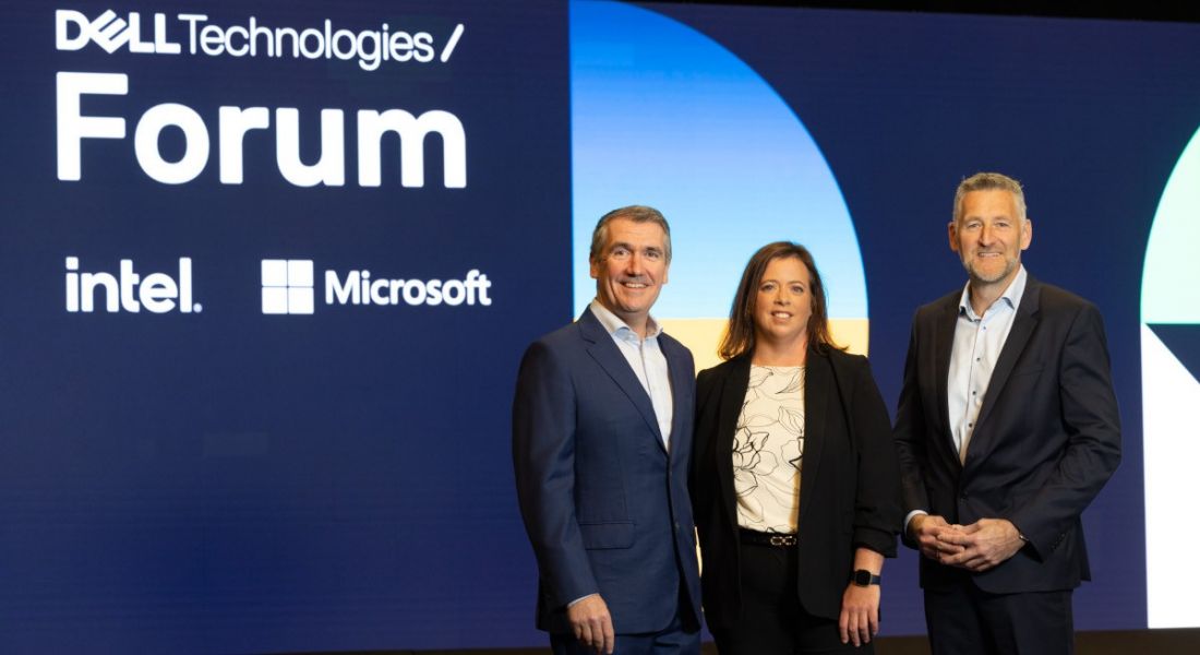 Three people from Dell Technologies standing on a stage with a sign for Dell Technologies Forum behind them.