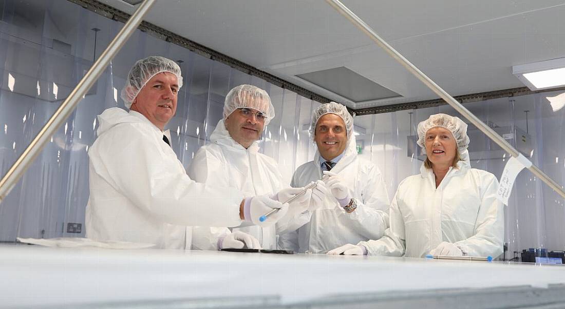 Four people stand in protective gear in the new EnerMech facility.