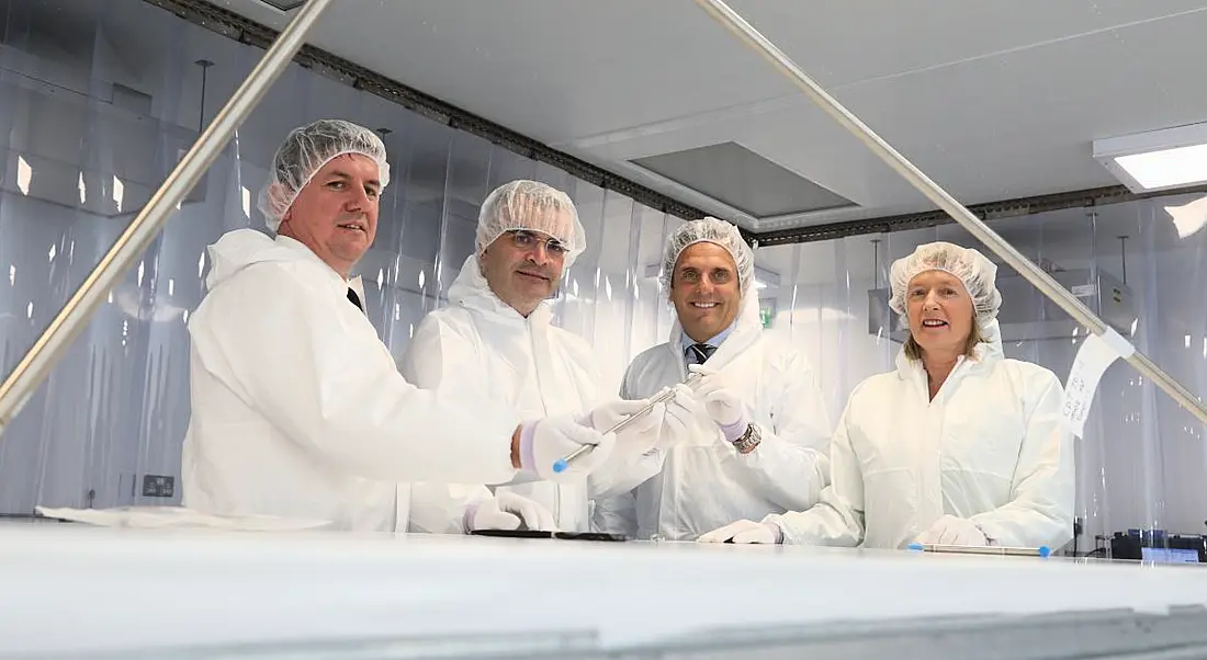 Four people stand in protective gear in the new EnerMech facility.