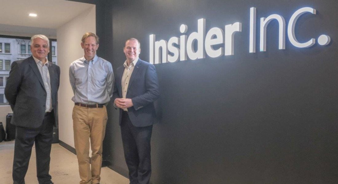 Three men stand beside a wall that says 'Insider Inc' on it.