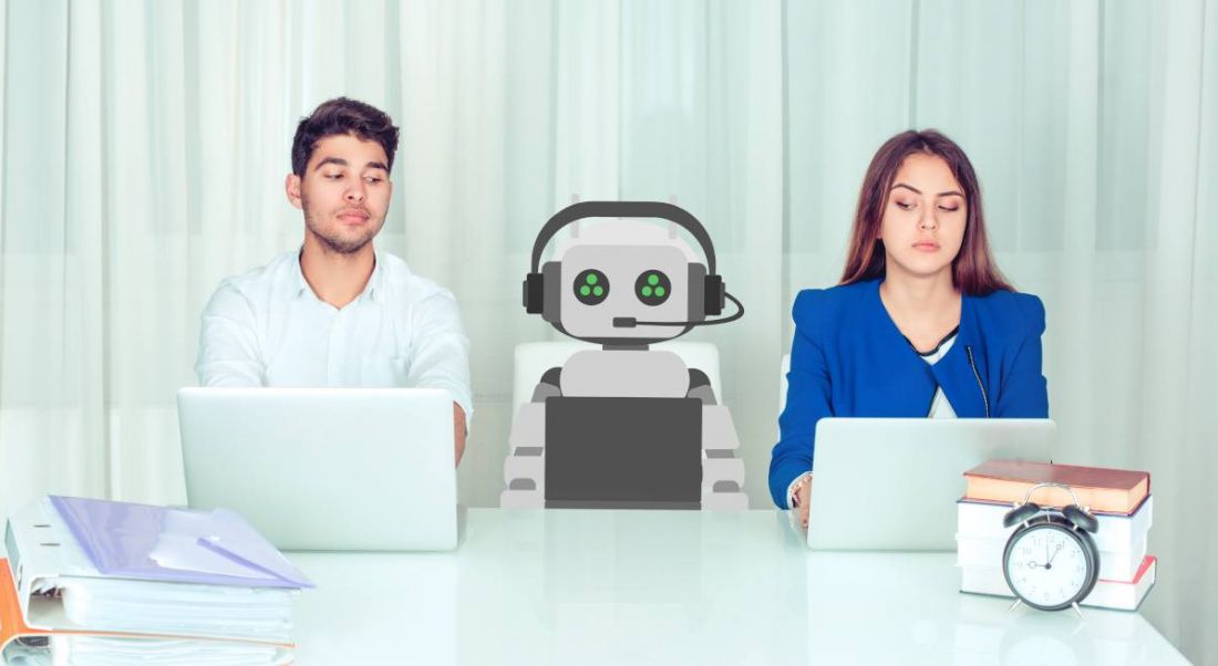 Man and woman at work in an office with an AI robot sitting between them and a clock and book binders on the desk.