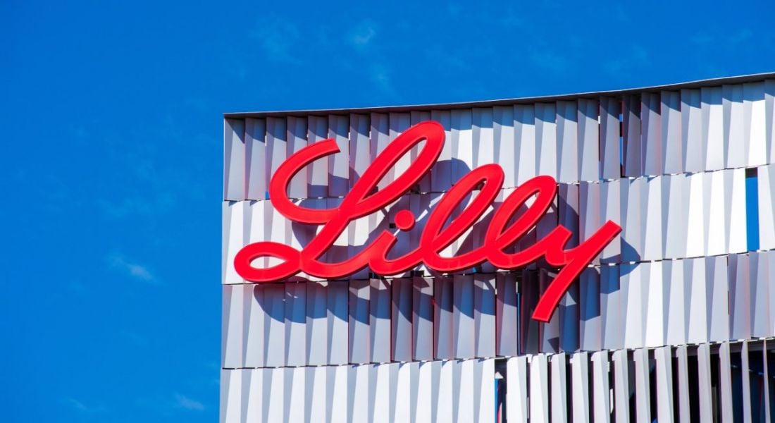 Eli Lilly logo on a building with blue sky above.