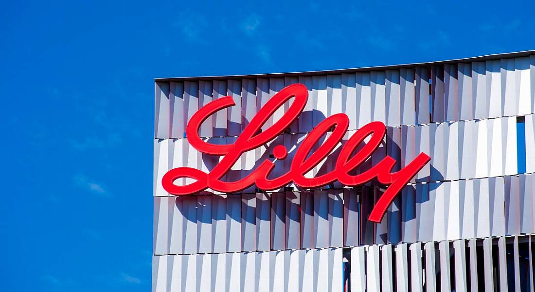 Eli Lilly logo on a building with blue sky above.