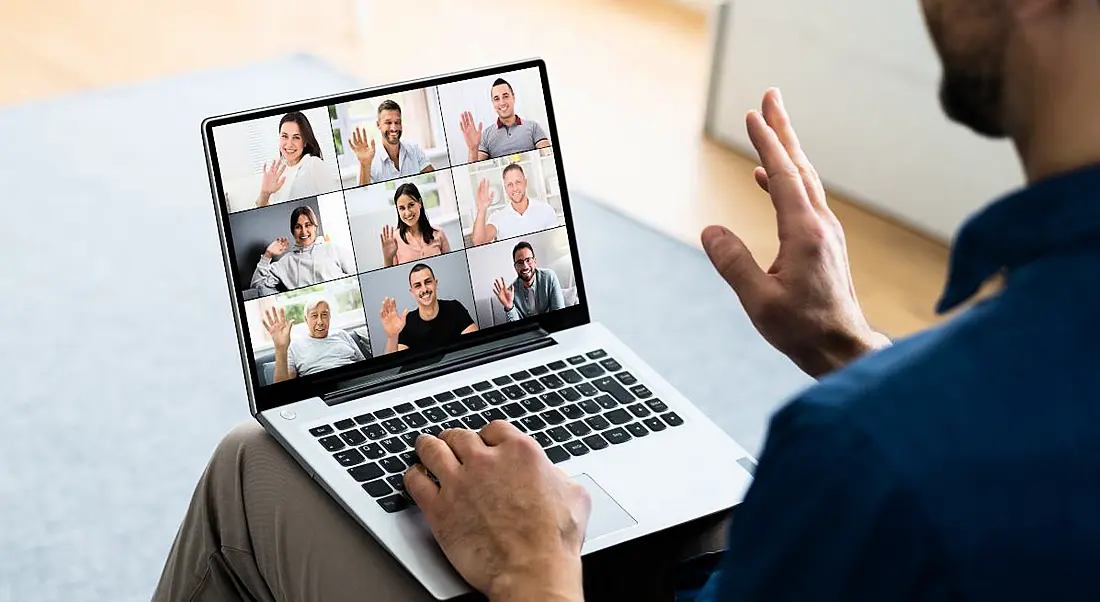 A man talking to colleagues using video conferencing software.