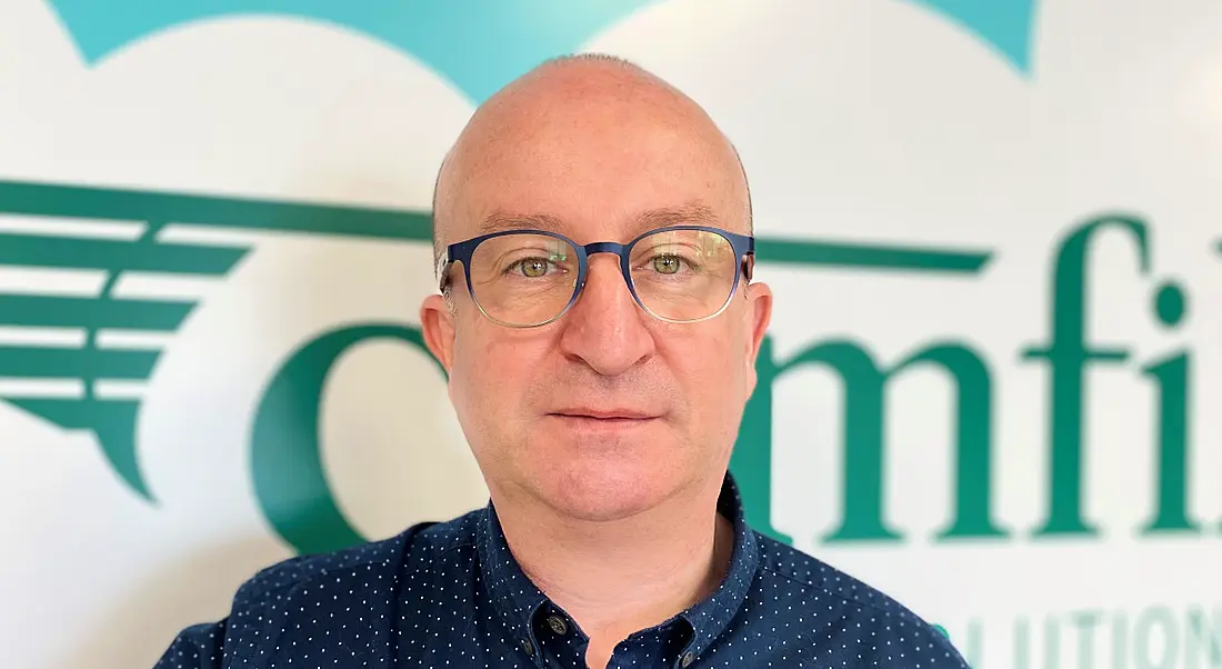 A headshot of Paul Flanagan standing against a wall with the Camfil logo on it.