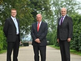 Four people stand in a line outside Government buildings in Dublin.