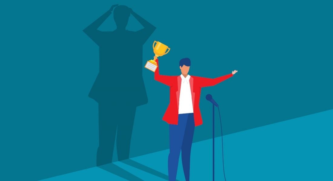 A vector image of a person standing in front of microphone excited and holding a trophy. Behind them, a shadow looks like it’s freaking out, symbolising imposter syndrome.