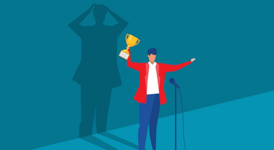 A vector image of a person standing in front of microphone excited and holding a trophy. Behind them, a shadow looks like it’s freaking out, symbolising imposter syndrome.