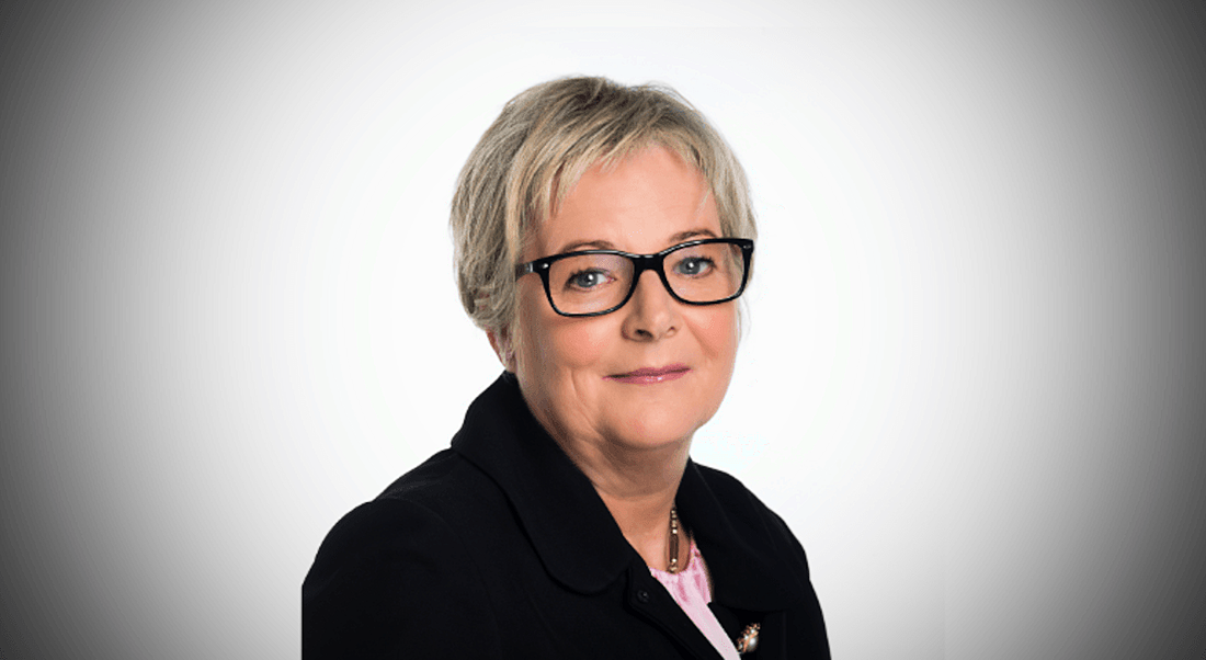 Headshot of a smiling woman with short hair wearing glasses.