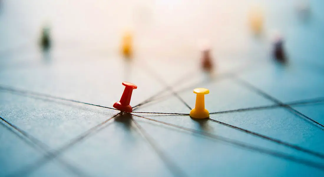 Pins on a blue board interconnected with string.