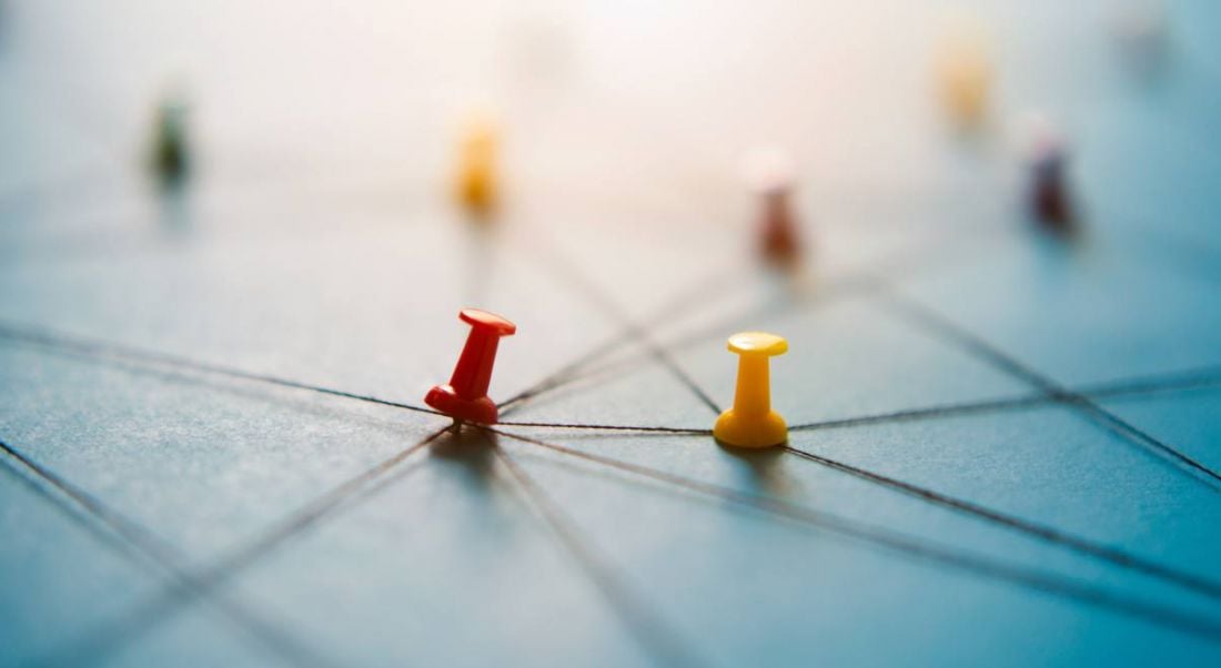 Pins on a blue board interconnected with string.