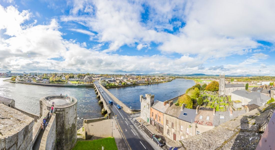Panoramic view of a bridge extending across the River Shannon from the city walls of Limerick.