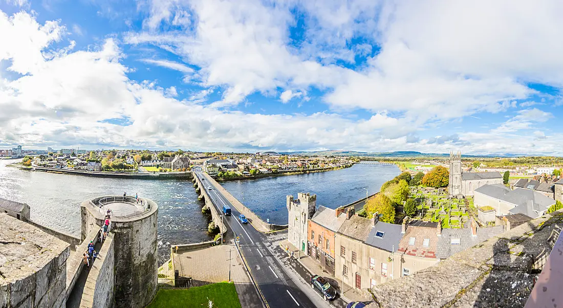 Panoramic view of a bridge extending across the River Shannon from the city walls of Limerick.