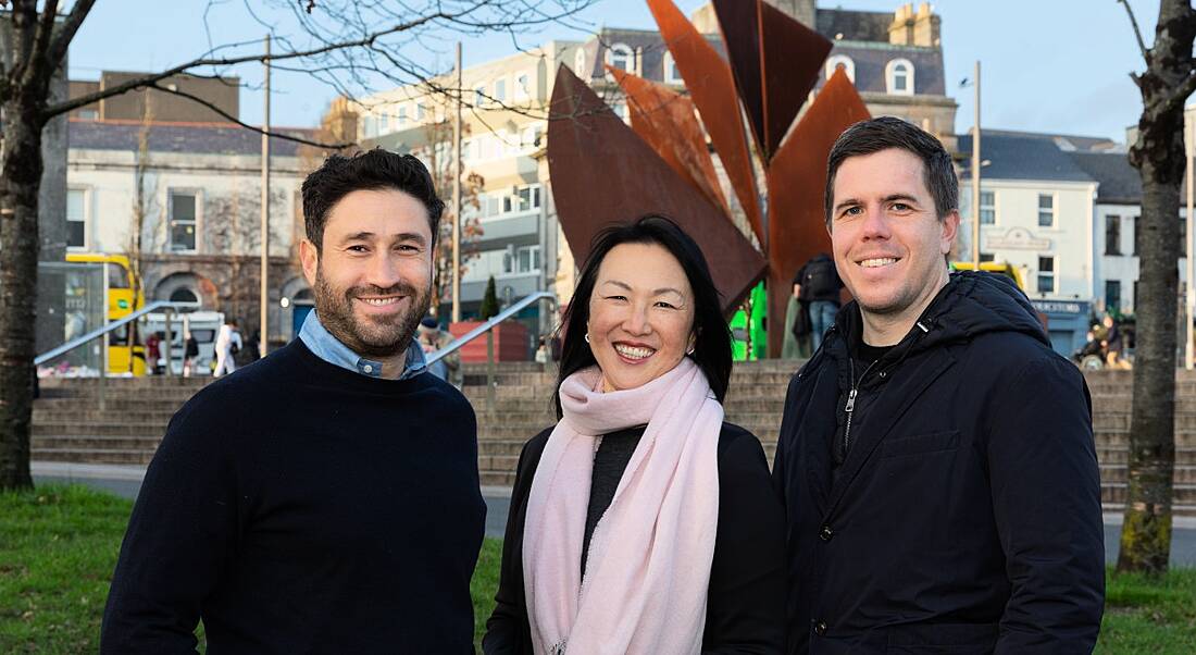 Two men and a woman standing smiling in Eyre Square Galway celebrating the opening of Signify Health’s new tech centre.