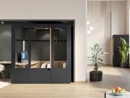 A contemporary office space with black walls, bright windows and wooden crate-box desks.