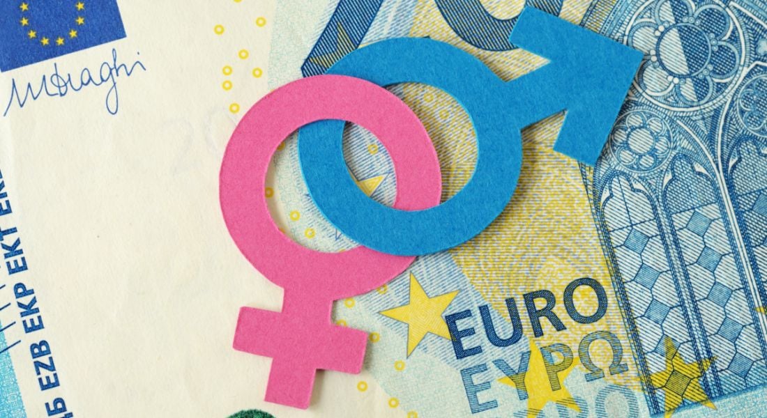 Gender symbols in pink and blue lying on a 20 euro note.