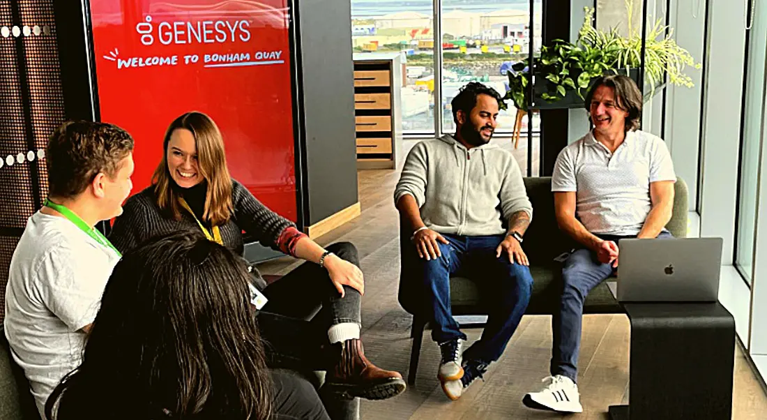 Genesys Galway employees sitting around in a bright, modern office.