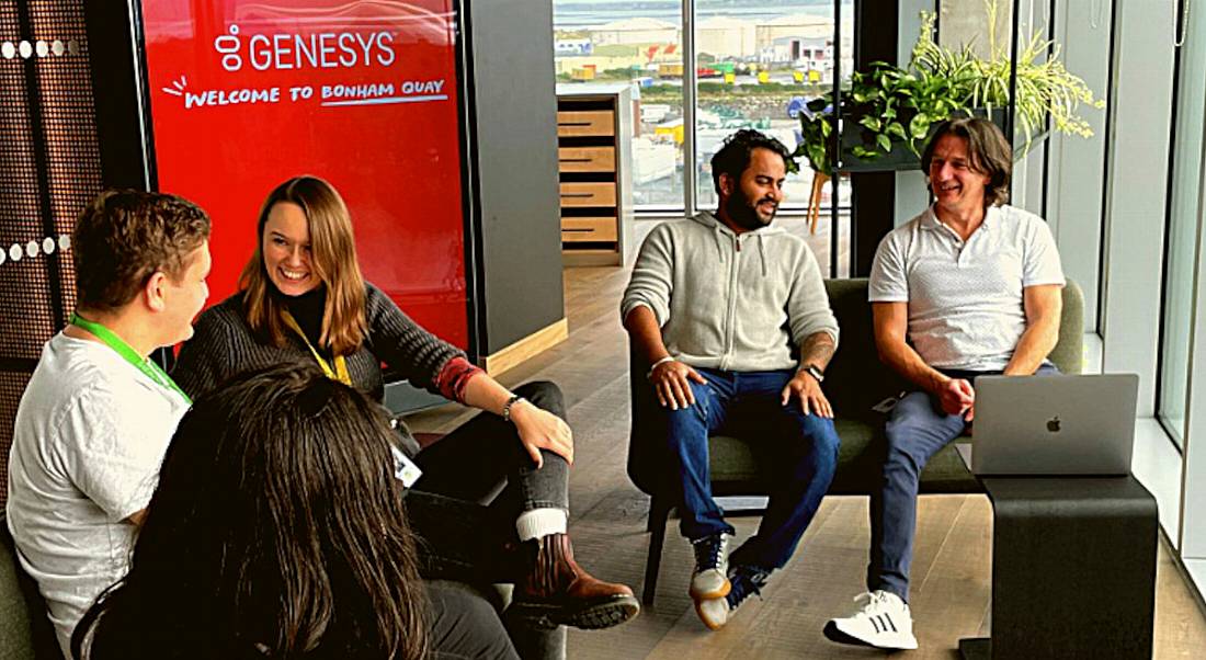 Genesys Galway employees sitting around in a bright, modern office.