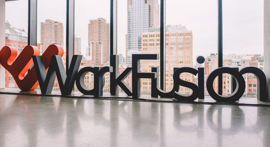 The WorkFusion name and logo are spelled out in large letters in an office space overlooking a cityscape.