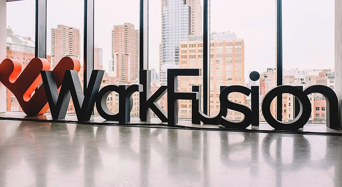 The WorkFusion name and logo are spelled out in large letters in an office space overlooking a cityscape.