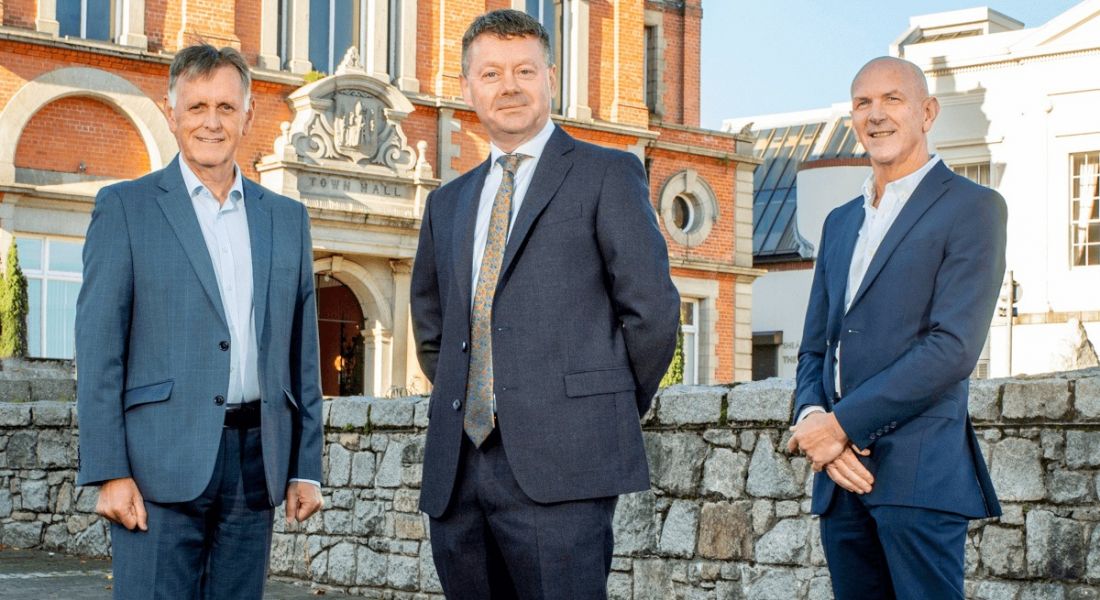 Mark Bleakney, southern regional manager, Invest NI; Kielty Hughes, CEO, ISx4; George McKinney, director of Technology and Services, Invest NI standing in a row outside a brick building.