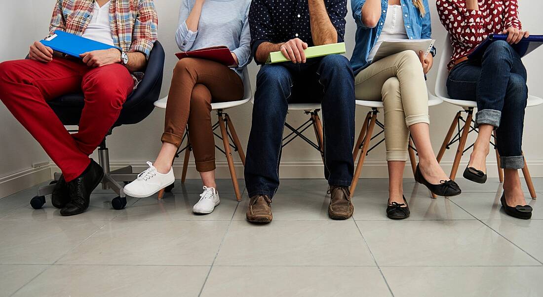 Four people waiting in a reception area for a job interview.