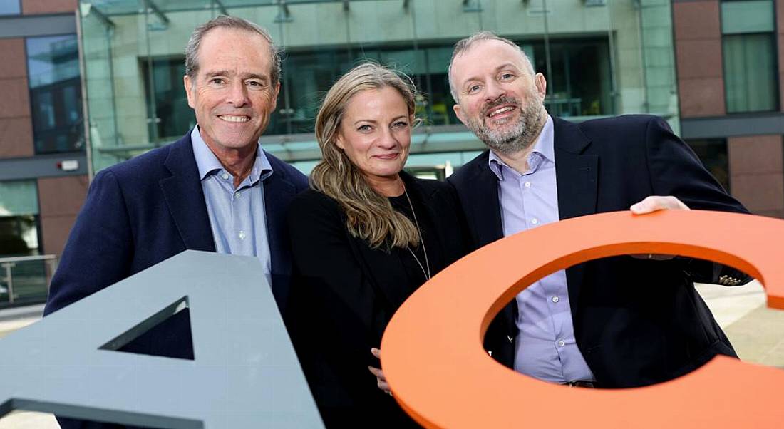 Two men and a woman standing holding the letters AC for Advanced Clinical.