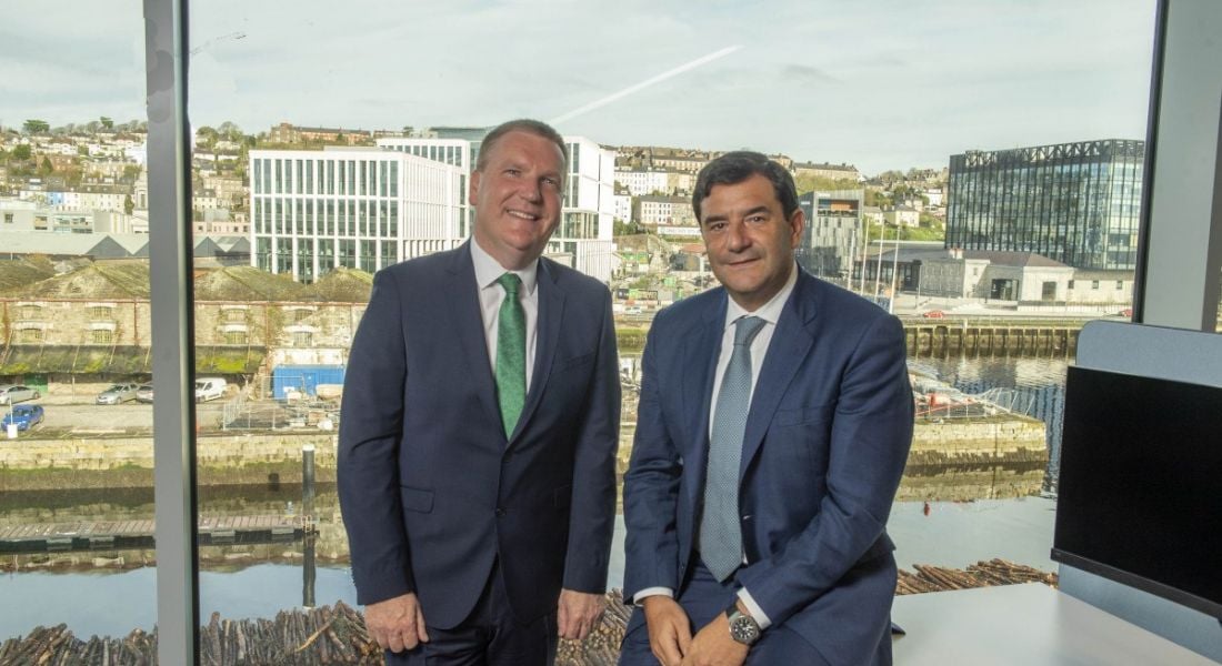 Minister Michael Mc Grath and Cesar Cernuda of Netapp stand in an office space overlooking Cork city.