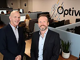 Peregrine Technologies CEO Paudy O’Brien is standing outdoors on a bridge.