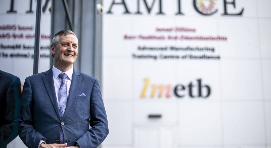 Martin O'Brien standing against a grey wall with the AMTCE and LMETB branding on it.