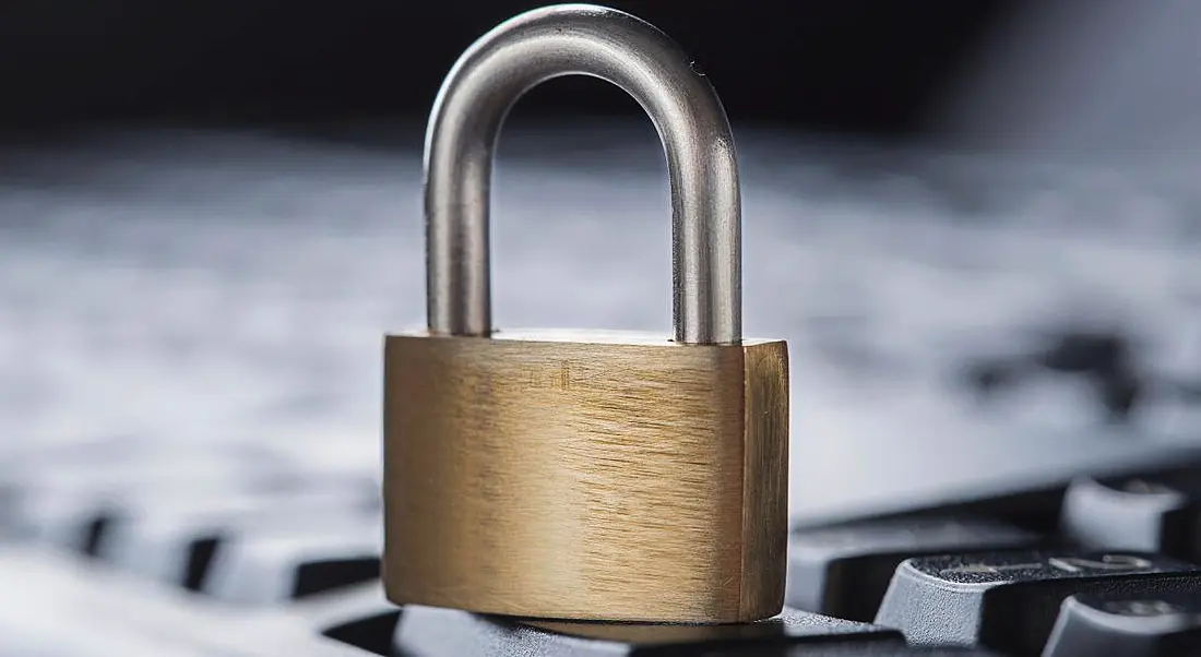 A padlock on a computer keyboard in a cybersecurity concept.