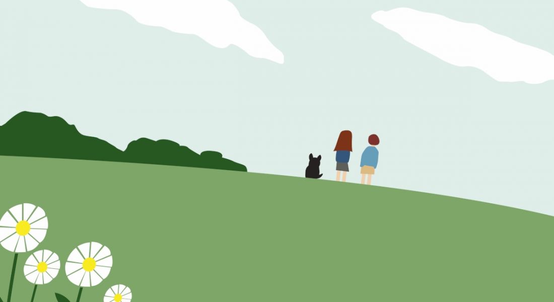 A cartoon showing two people standing on a green hill with a little black dog or cat. There are daisies in the foreground and a sky in the background.