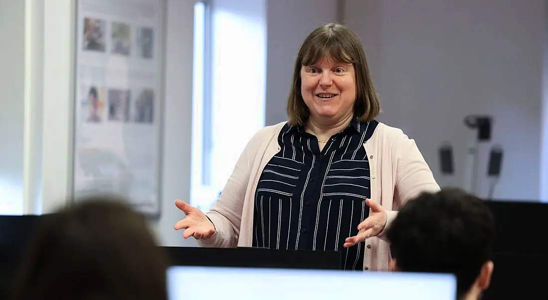 Louise Hopper of DCU Futures standing in front of some students talking to them. They are in a classroom.