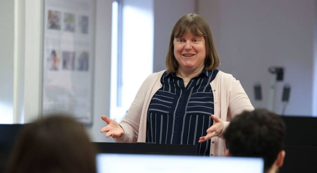 Louise Hopper of DCU Futures standing in front of some students talking to them. They are in a classroom.