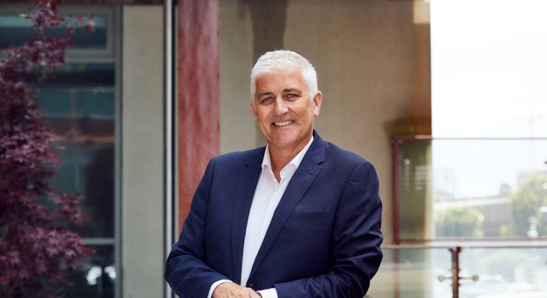 A man in a suit leaning on a railing, with a building wall behind him. He is Ronan Murphy, the CEO of CWSI.