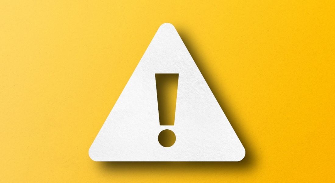 A hazard warning sign in white against a yellow background, symbolising danger.