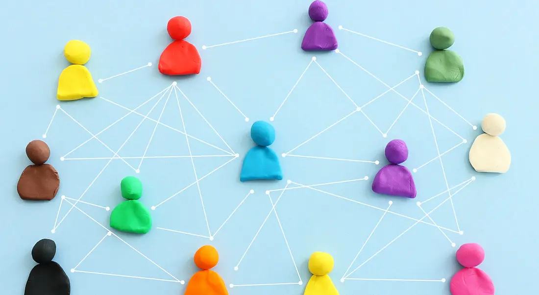 Figures made from playdough connected by white lines on a blue background in professional networking concept.