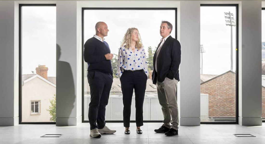Three people from Logicalis standing in an empty office space.
