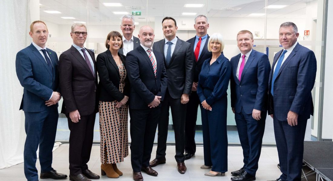 A group of ten people standing together in a bright white room at the opening of BioMarin Cork's new expansion.
